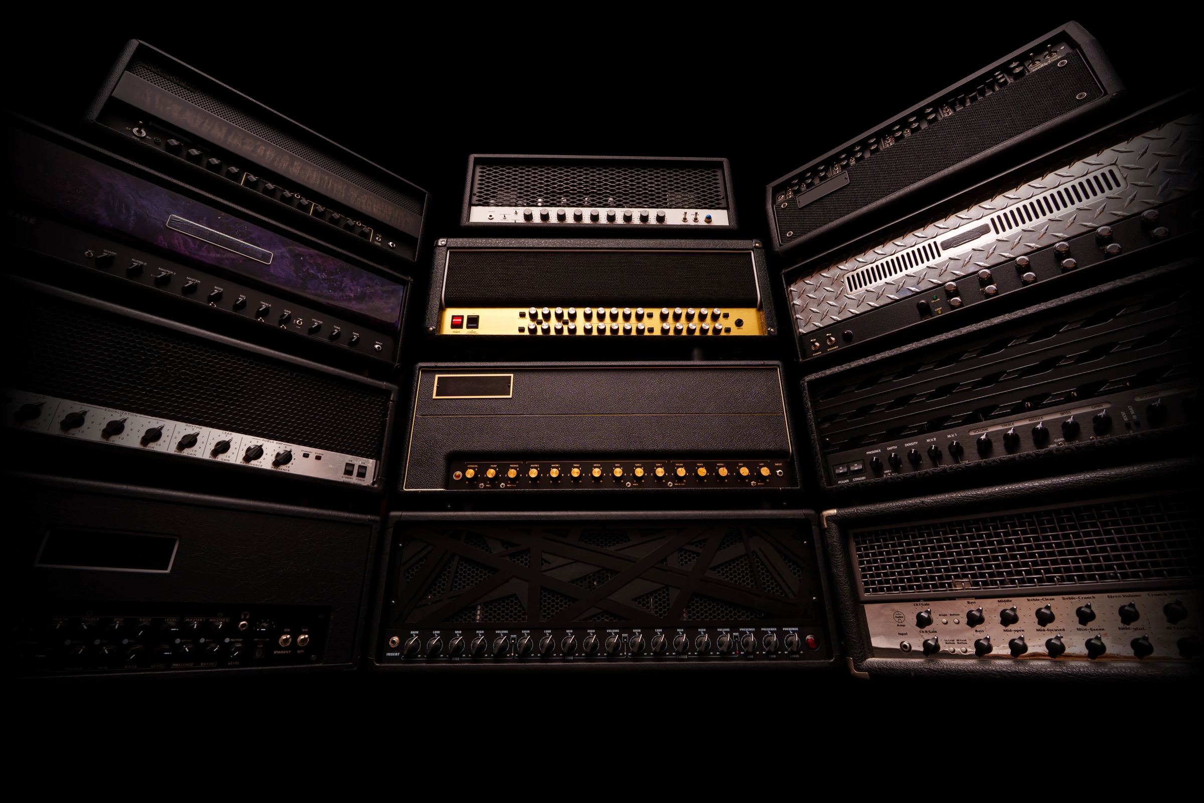 A wall of high-gain amp heads in a dark room